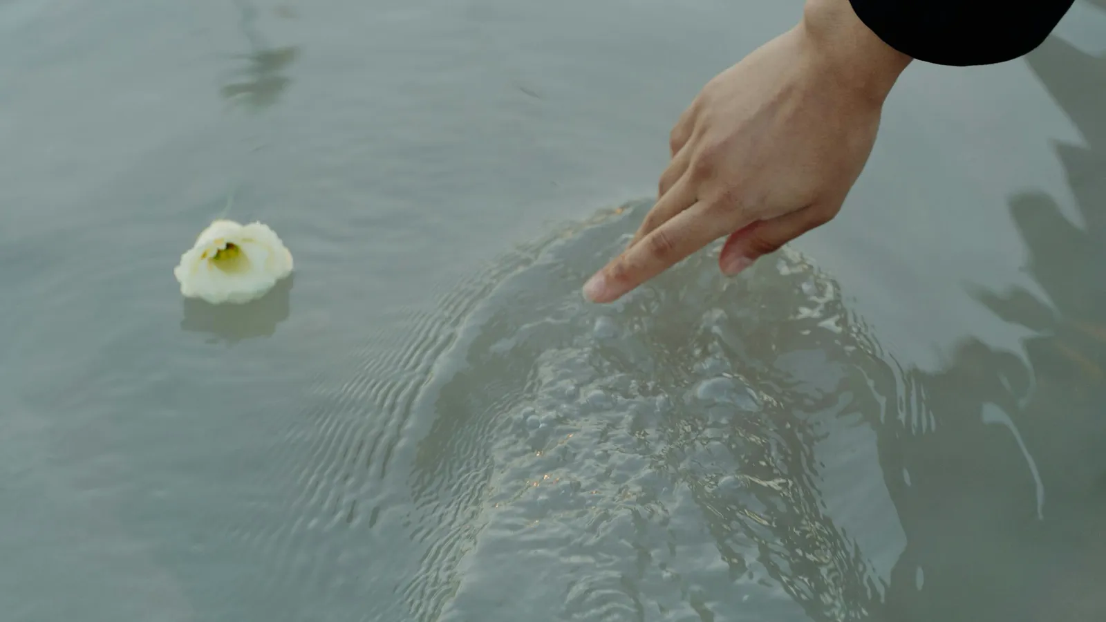 Una mano rozando la superficie del agua